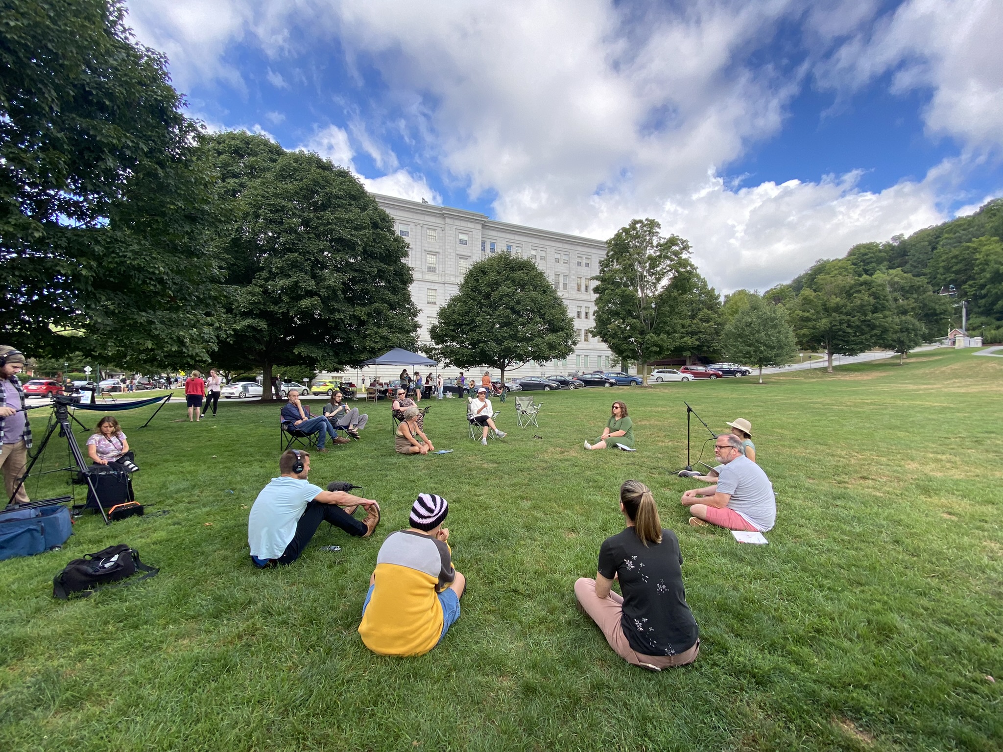 Vermont community members sitting on the State House Lan in a circle, celebrating community.
