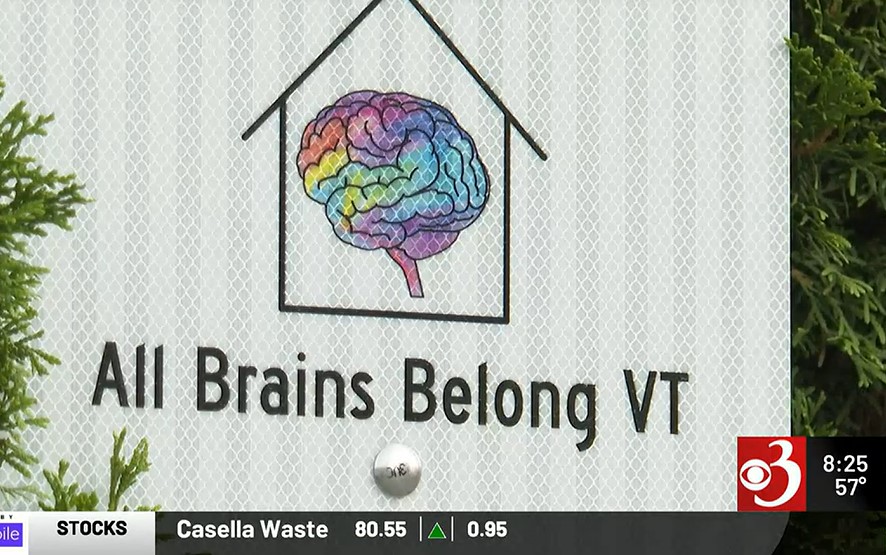 Screenshot from WCAX coverage showing All brains belong logo with rainbow brain inside a house, showing WCAX 3 logo.